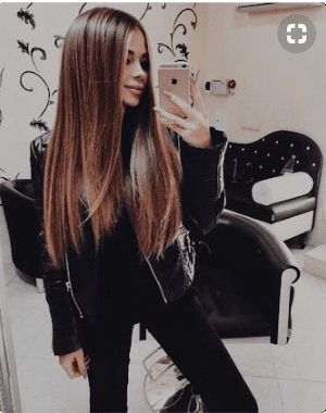 Young woman with long brunette hair in all black outfit.