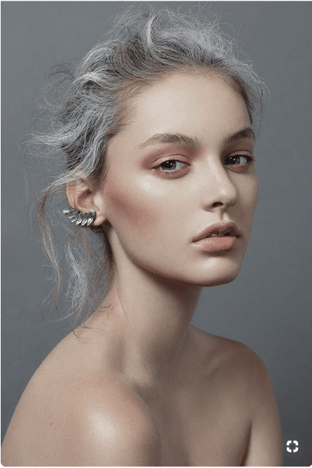 Woman with grey/blonde hair and icy makeup.