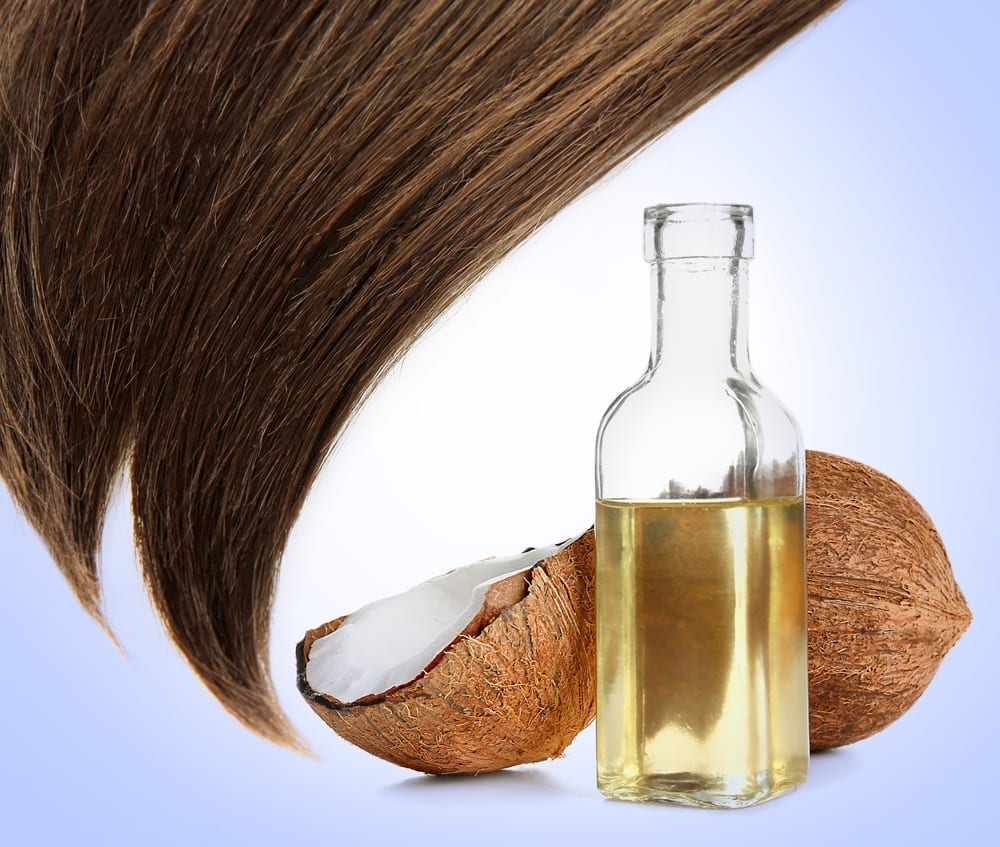 Shiny brown hair next to a coconut and coconut oil.